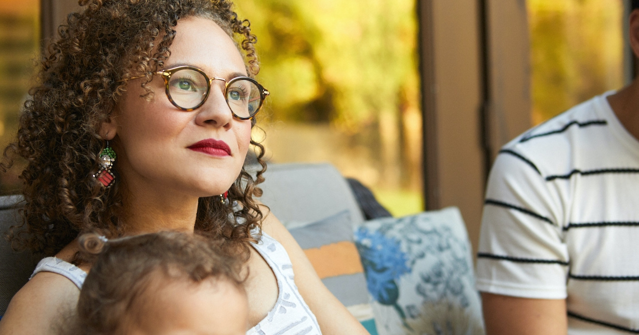 A mother sits outside with her child in her lap. 