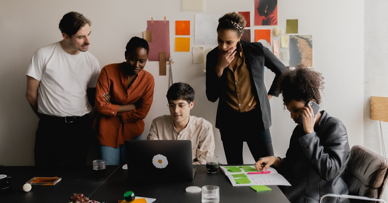 A photo of a team of men and women working together in an office. 