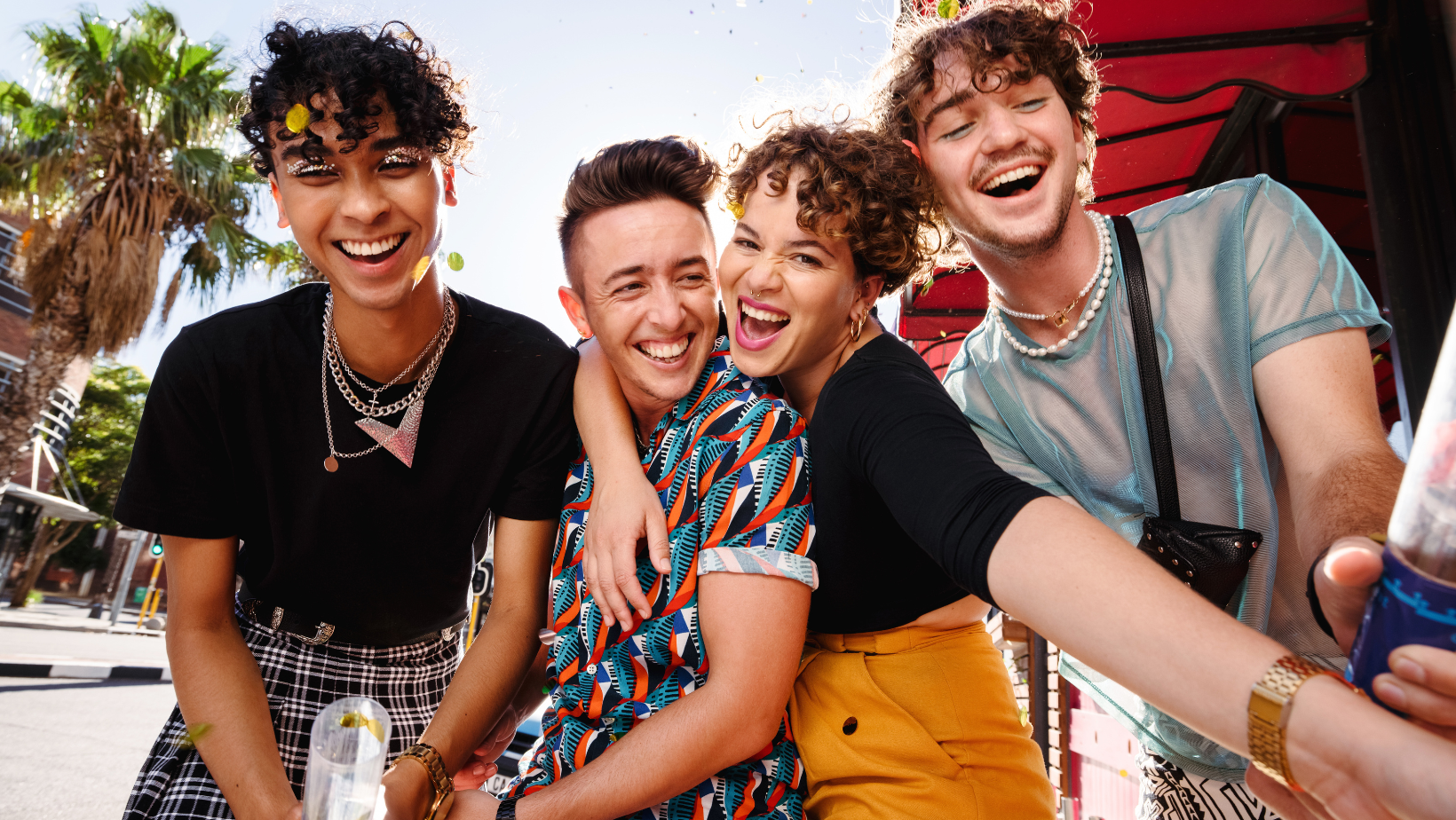 Friend group hugging and laughing.
