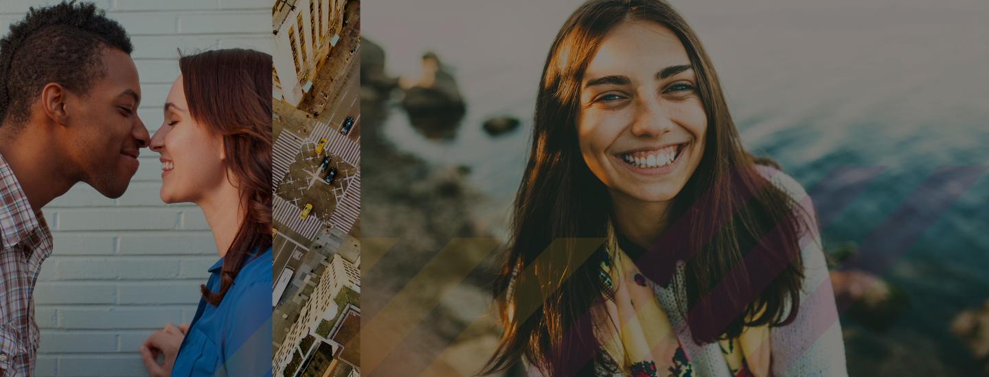 A couple touches noses and a woman smiles at the camera. 