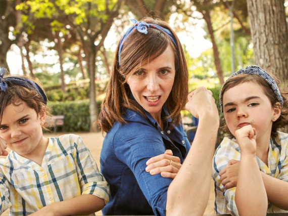A mother with a daughter on either side showing off their muscles