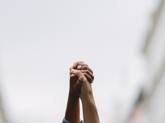 Two people hold hands and raise them up in the air 
