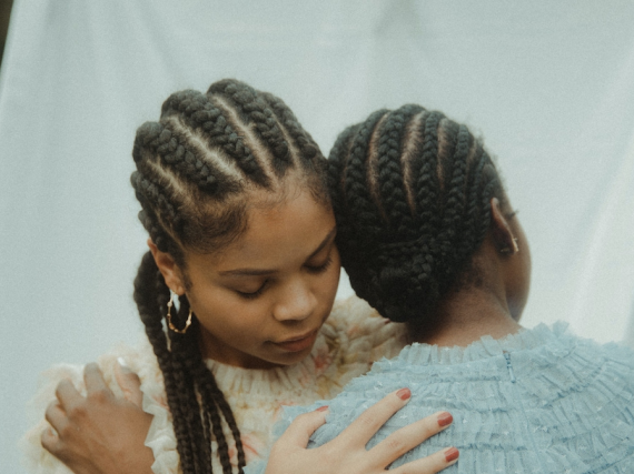 A photo of two sisters hugging gently. 