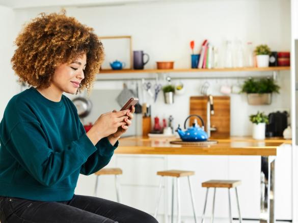 Woman on phone in her kitchen 